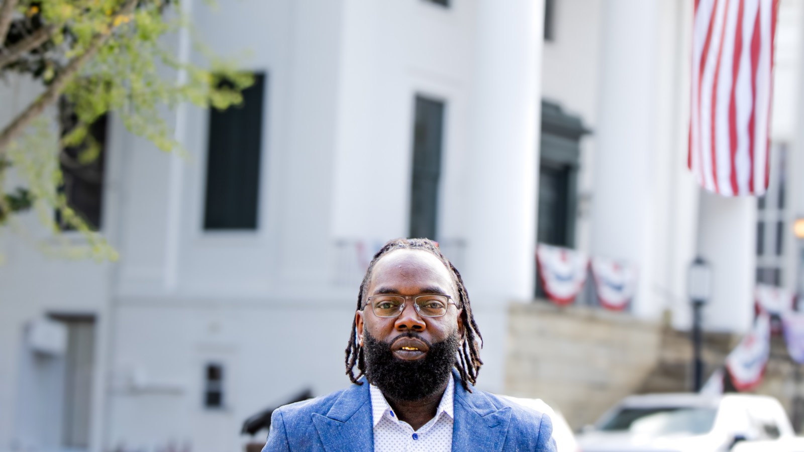 LaRon Washington downtown, with a flag-draped civic building behind him